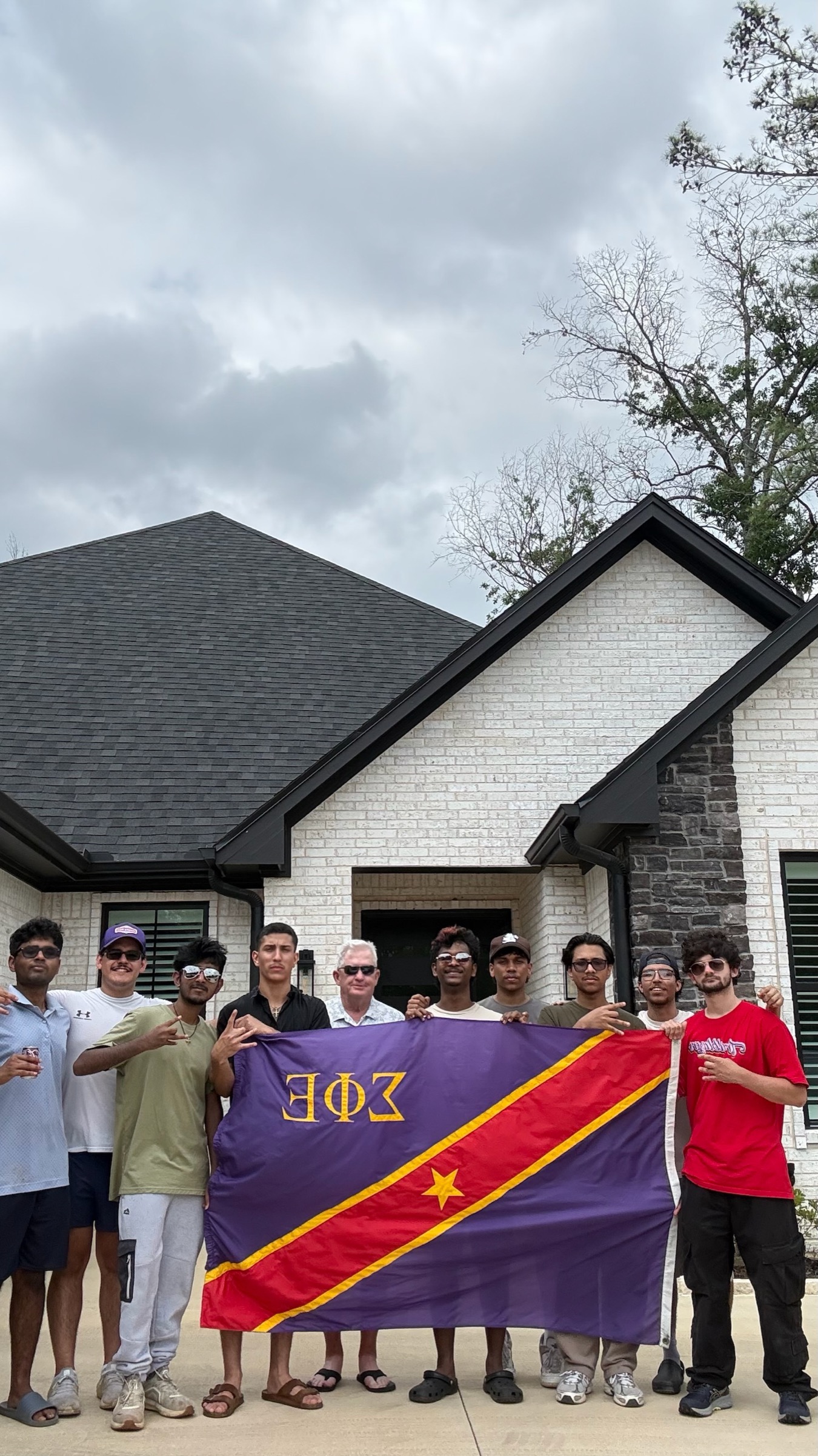 Brothers holding the SigEp flag outside a chapter event.